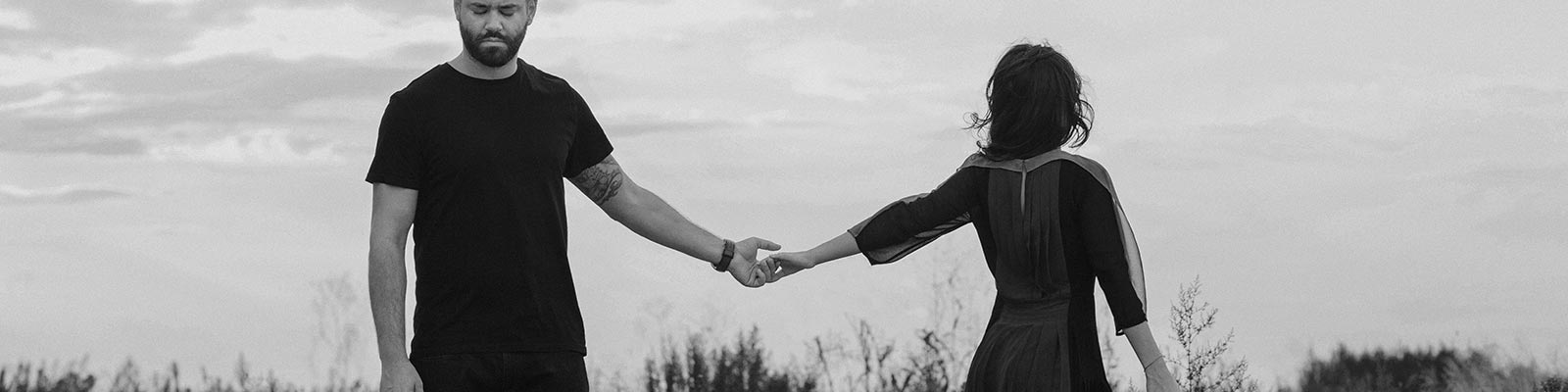 couple holding hands looking away