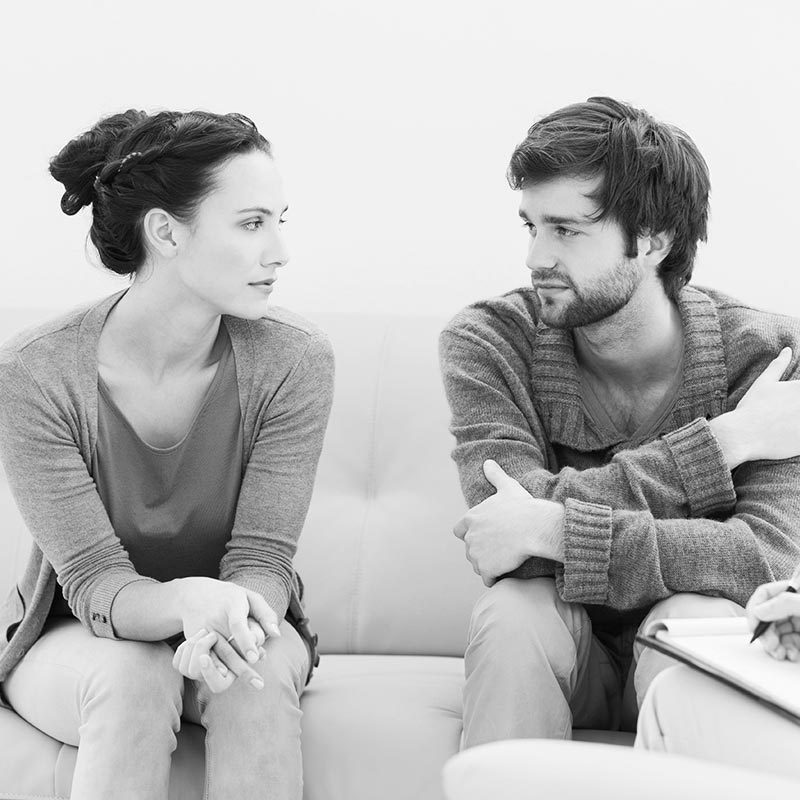 man and woman on couch talking