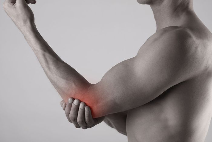 a man is holding his elbow in pain