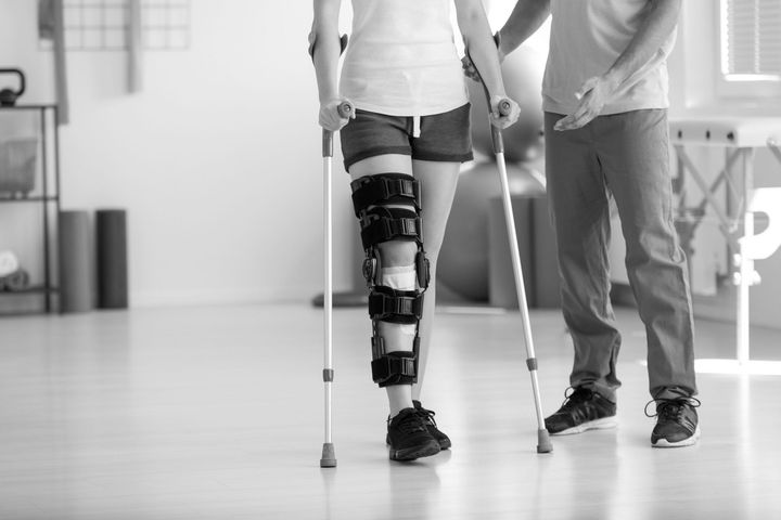 a man is helping a woman with crutches walk