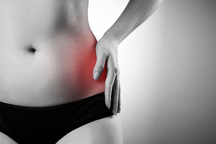 a woman is holding her hip in pain