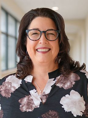 a woman in a black shirt is smiling for the camera