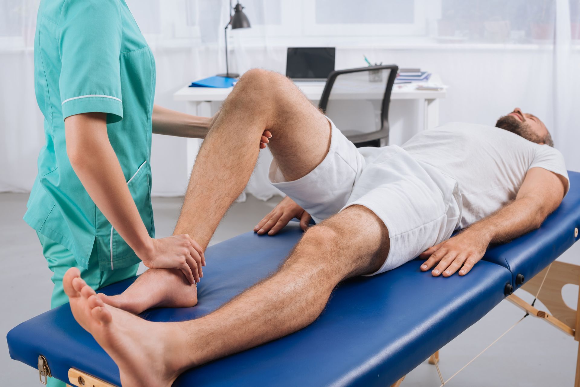 a man is laying on a table while a doctor examines his leg