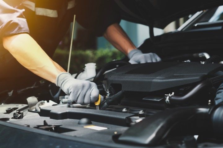 A man is working on the engine of a car.
