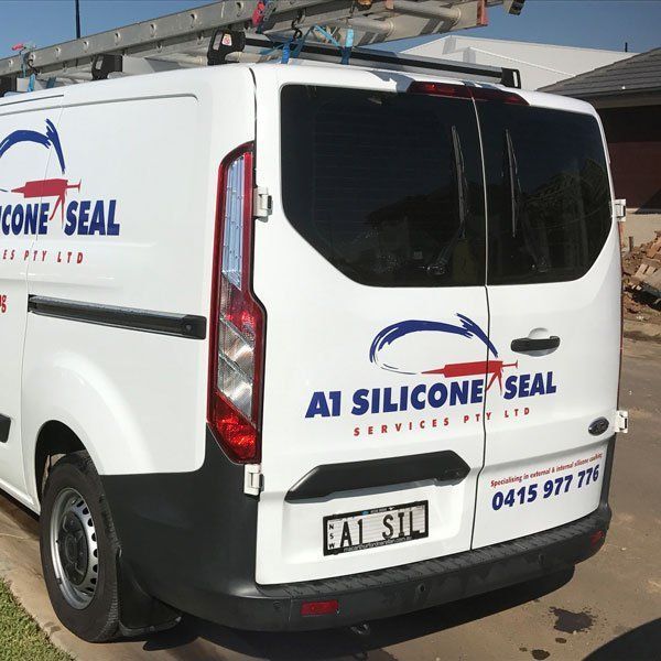 A white van that says a1 silicone seal on the back