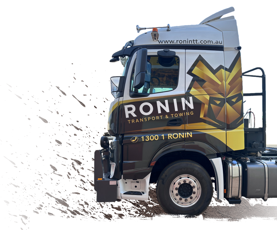 Excavator loading dirt into an orange dump truck on a construction site under a blue sky.