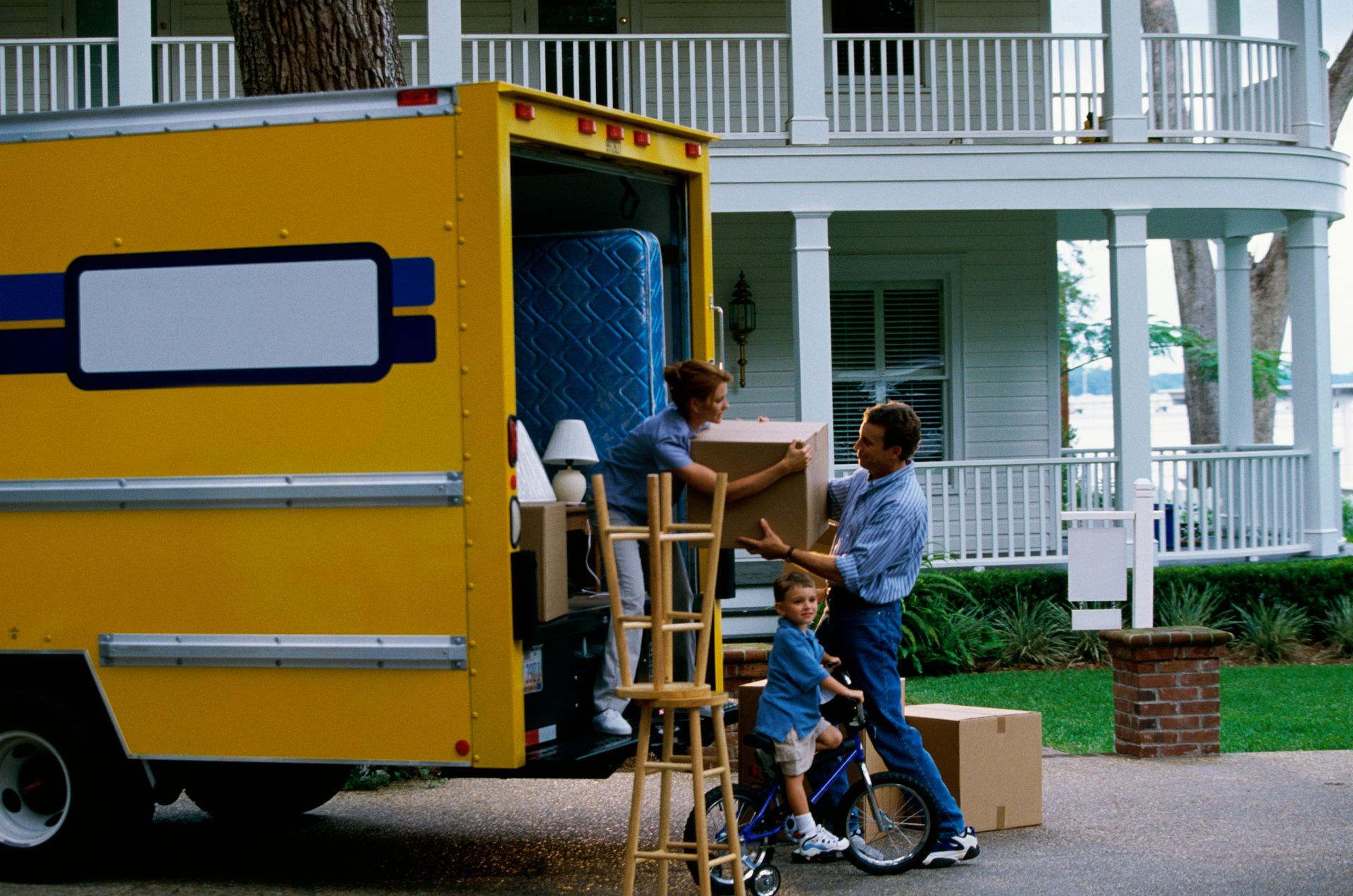 A family loading their belongings into a moving truck with Christofferson Moving & Storage, making l