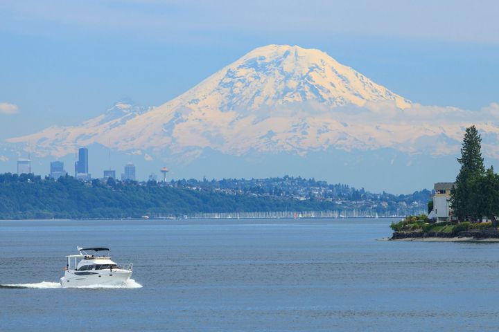 A boat is floating on a lake with a mountain in the background.