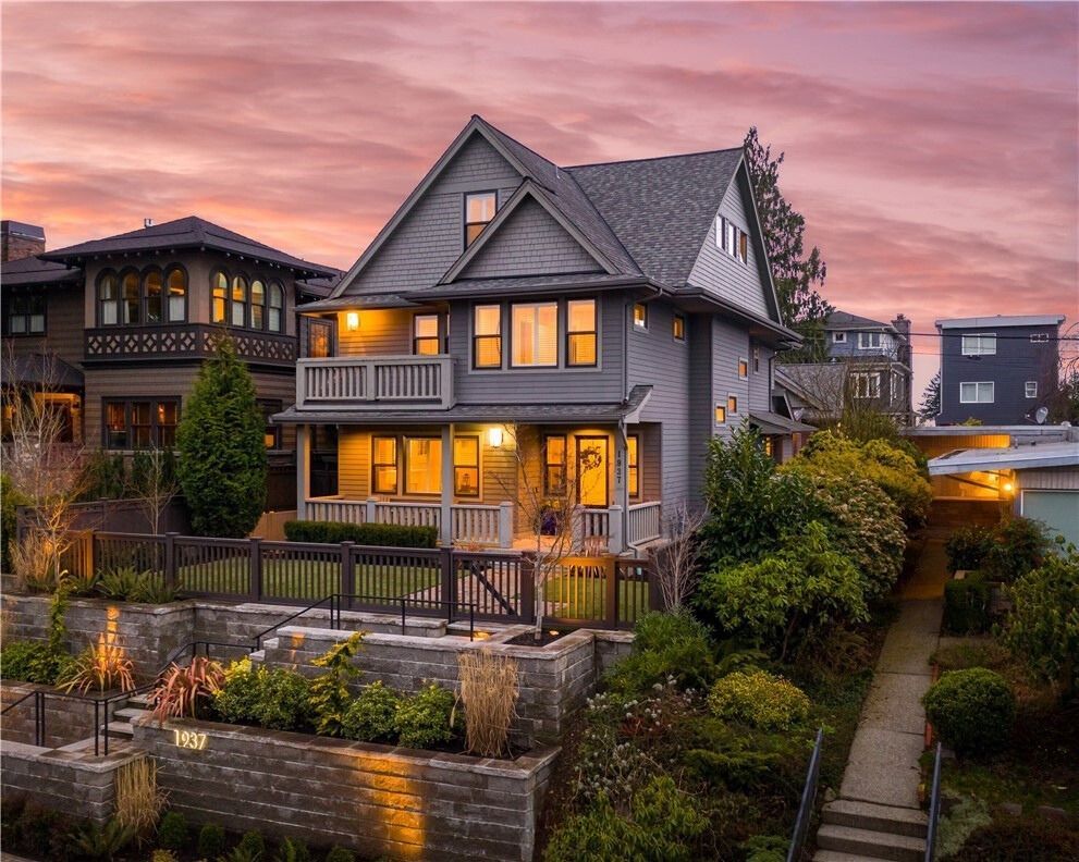 A modern house with a lot of windows and a large lawn in front of it.
