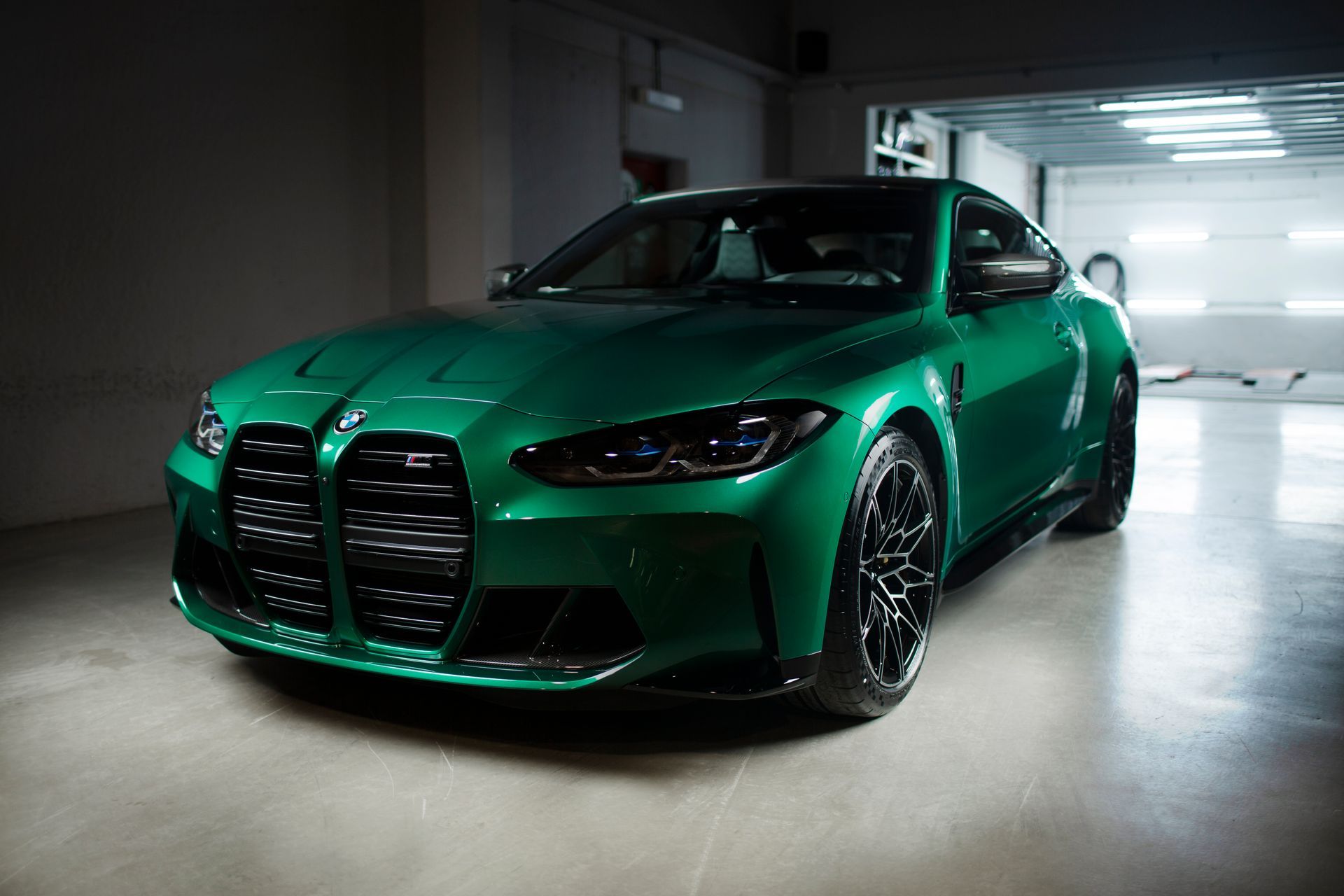 A green bmw m3 is parked in a garage.