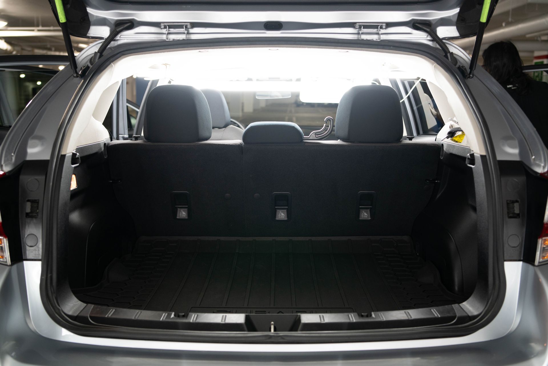 Empty cargo area of a silver hatchback car with rear seats folded down.