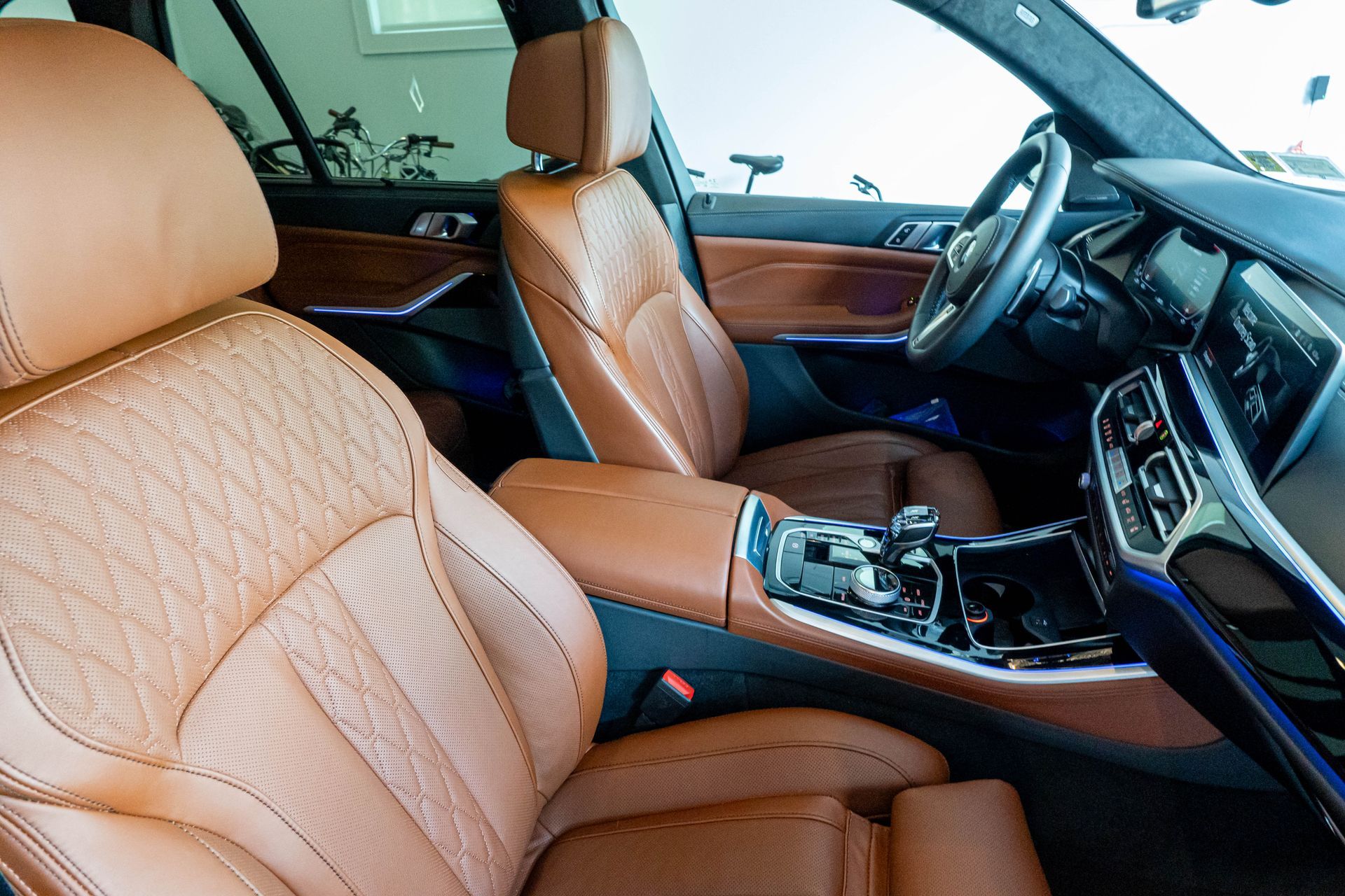 The interior of a car with brown leather seats and a steering wheel.