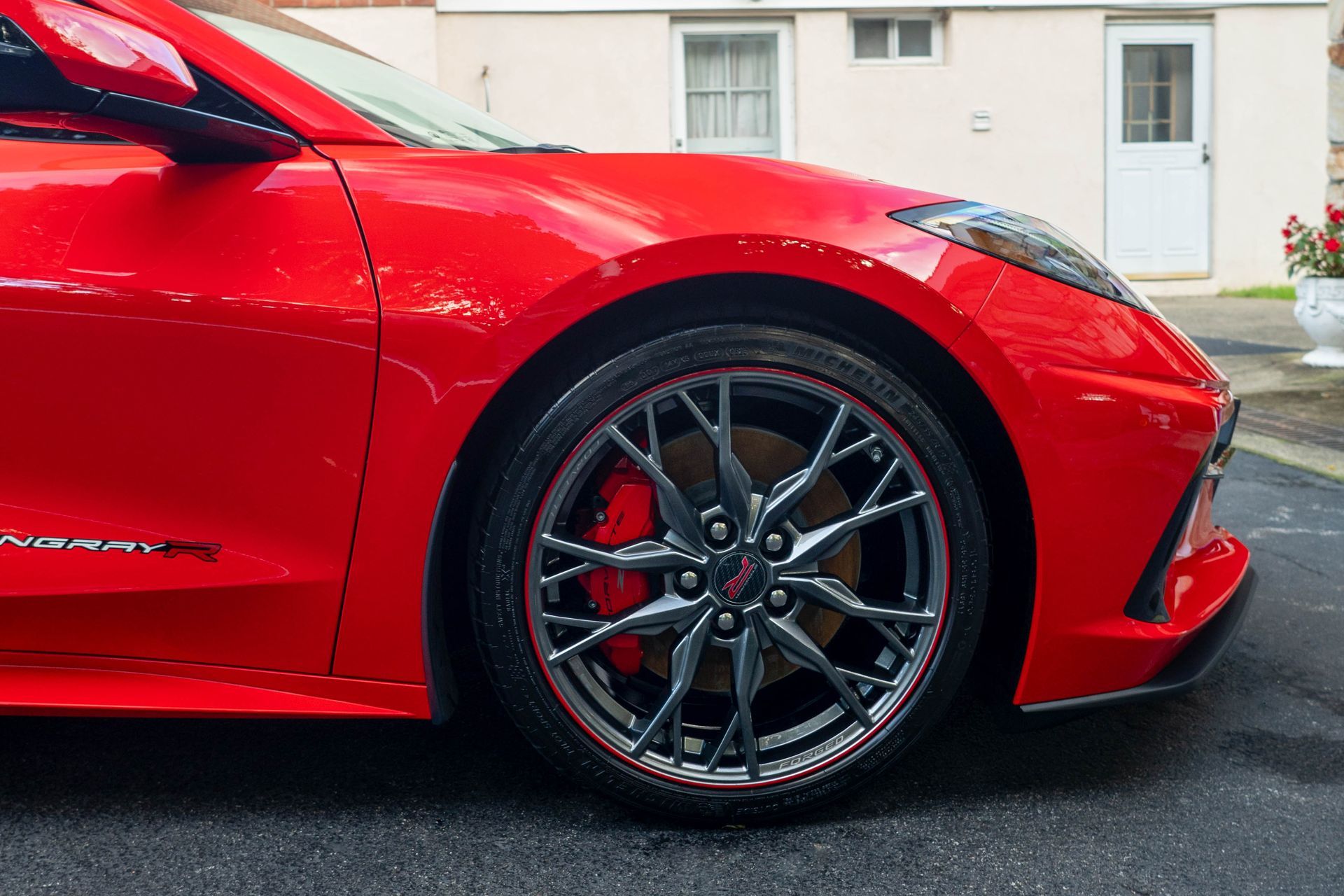 A red sports car is parked in front of a house.