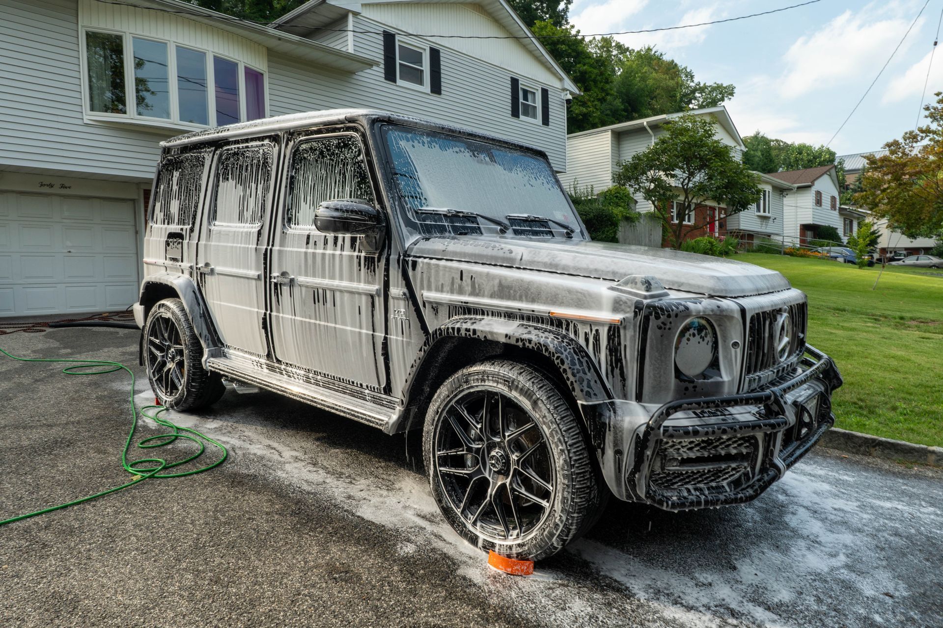 a mercedes is covered in foam in front of a house