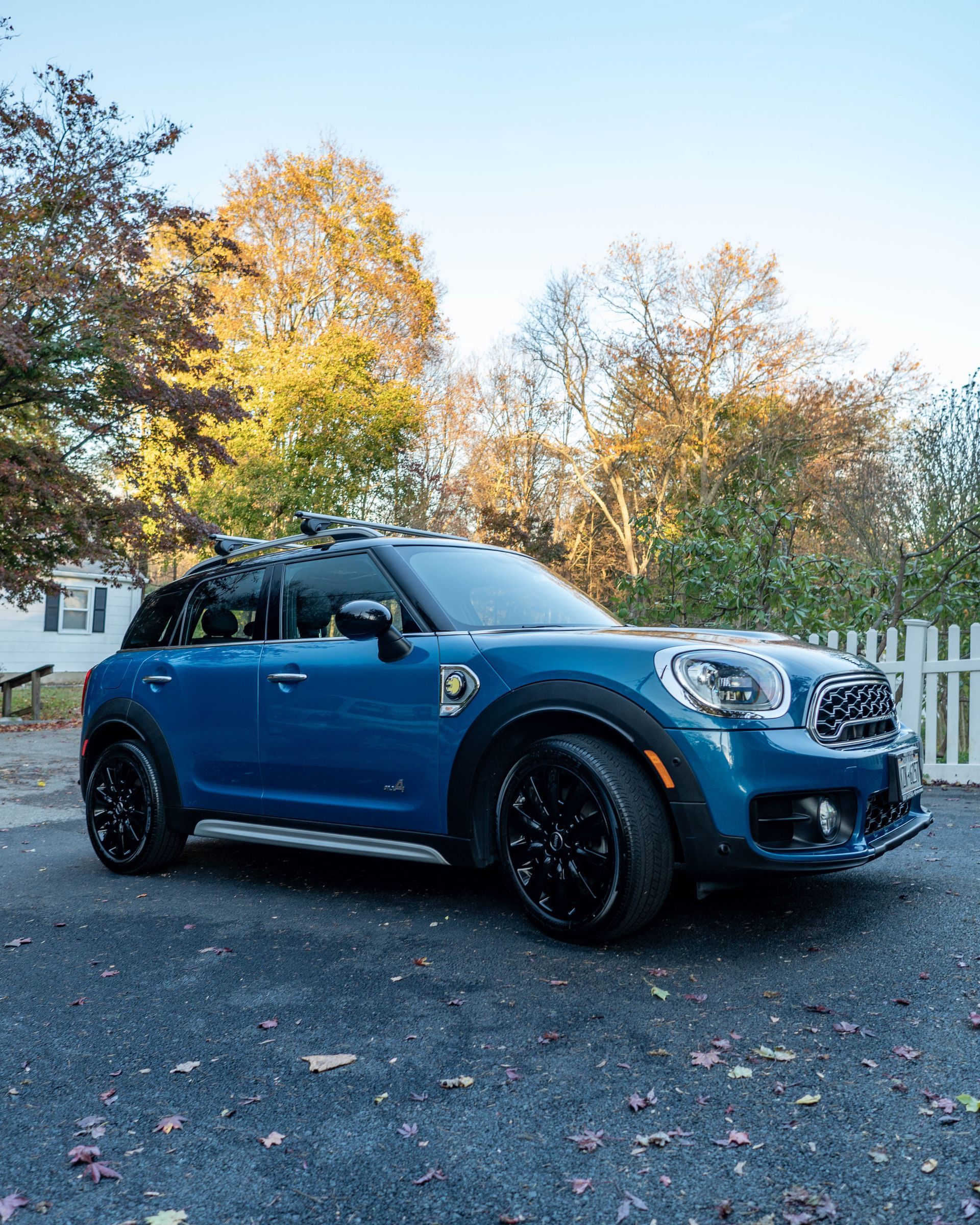 A blue mini cooper countryman is parked in a driveway.