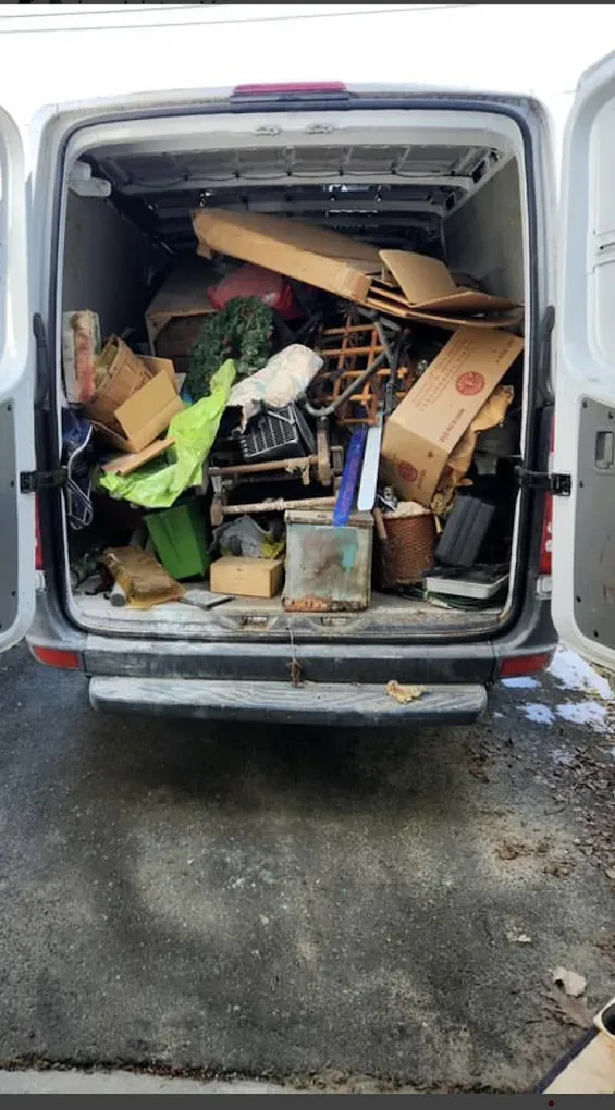 The back of a van is filled with lots of junk.