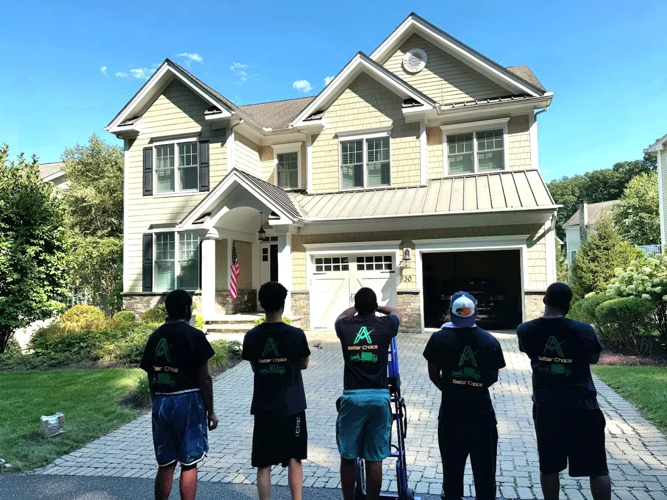 A group of men are standing in front of a large house.