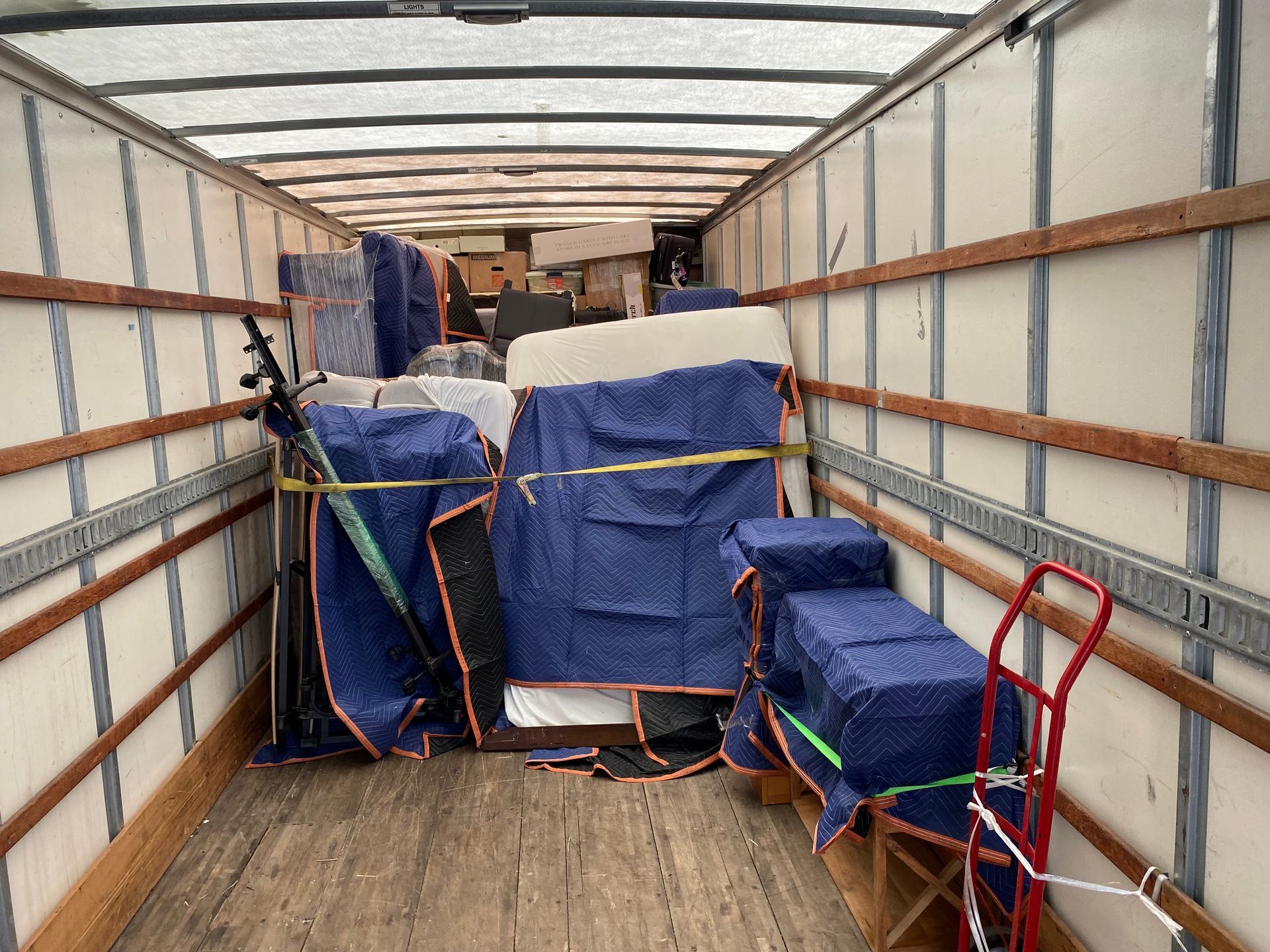 The inside of a moving truck filled with furniture and boxes.