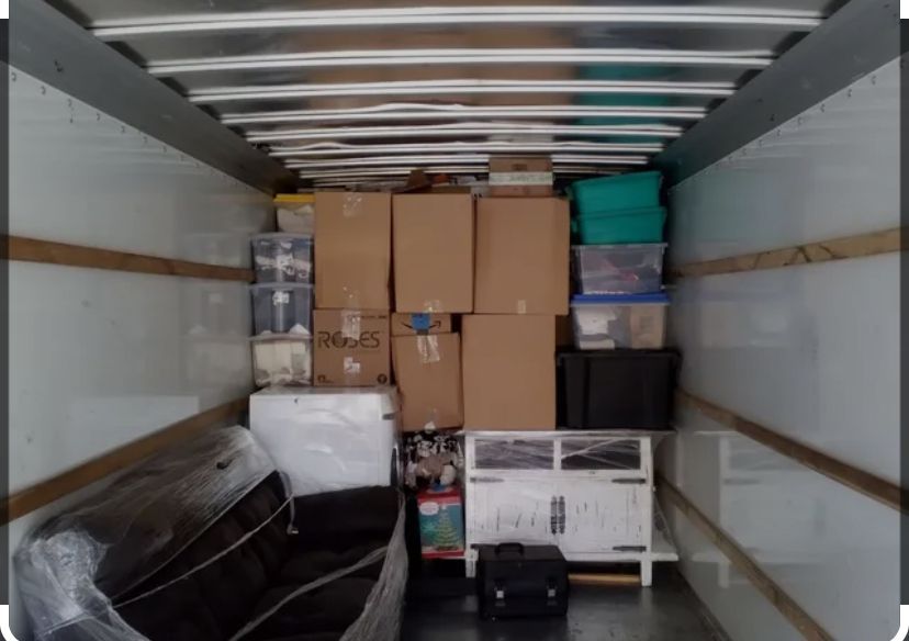 The inside of a moving truck filled with boxes and a couch