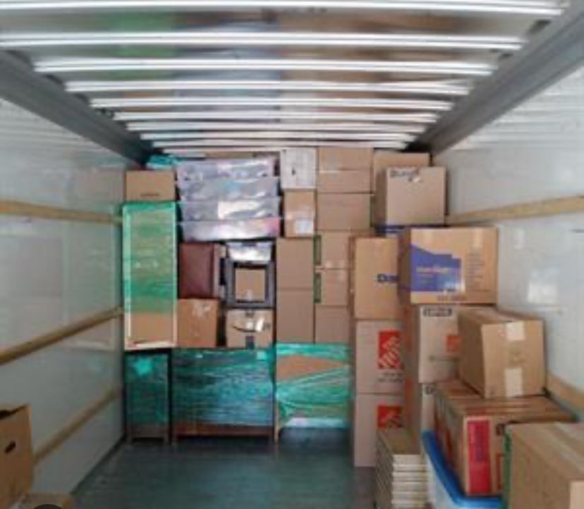 The inside of a moving truck filled with boxes including one that says home depot