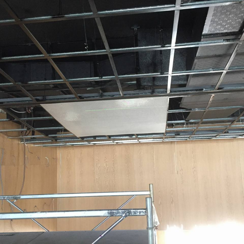 Realizzazione di un controsoffitto con griglia metallica e pannello bianco parzialmente installato. Vista interna.
