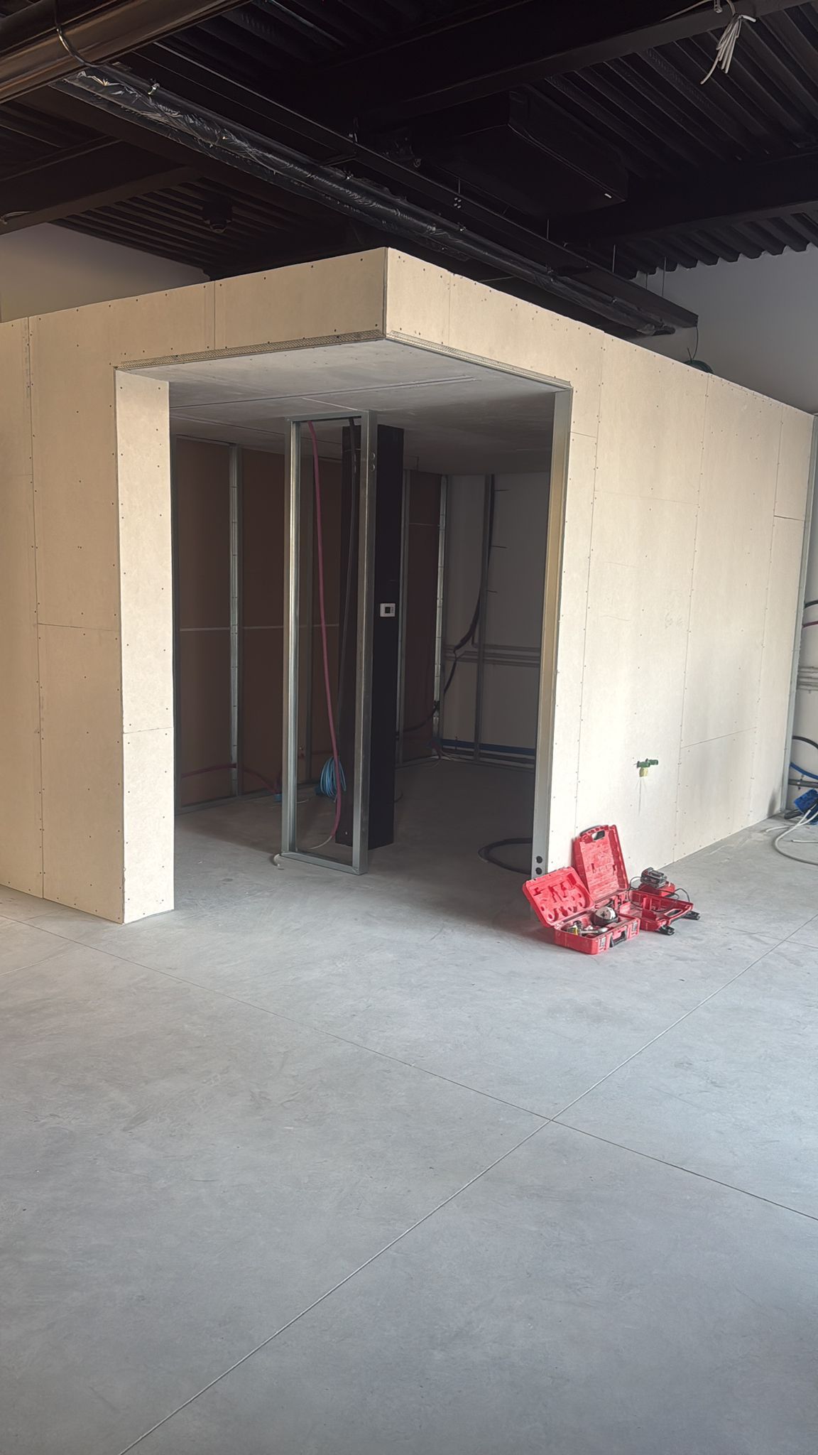 Interni in costruzione; pareti e soffitto in cartongesso non finiti, struttura metallica a vista.