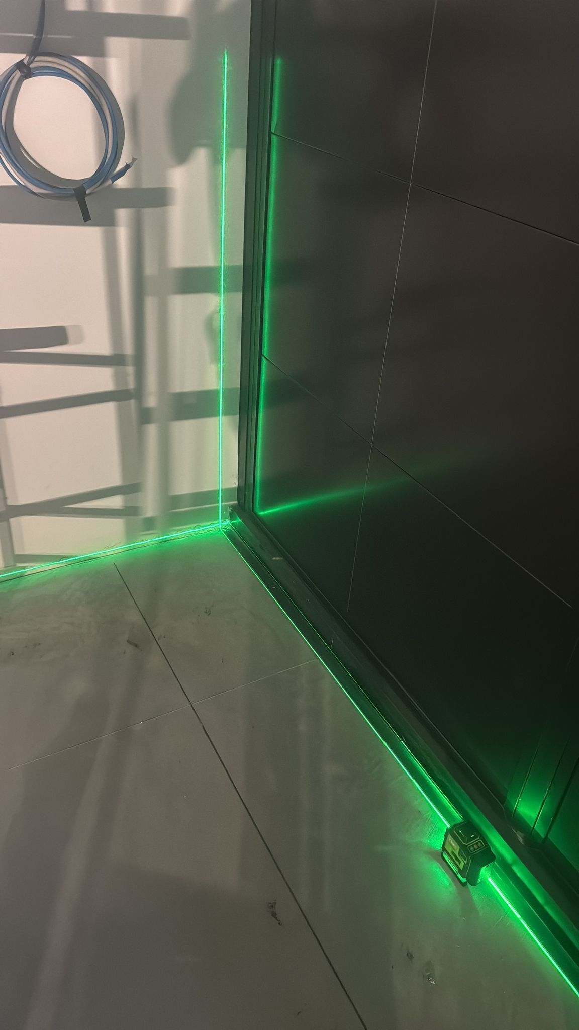 Striscia LED verde che illumina l'angolo di una stanza, per verificare le linee.