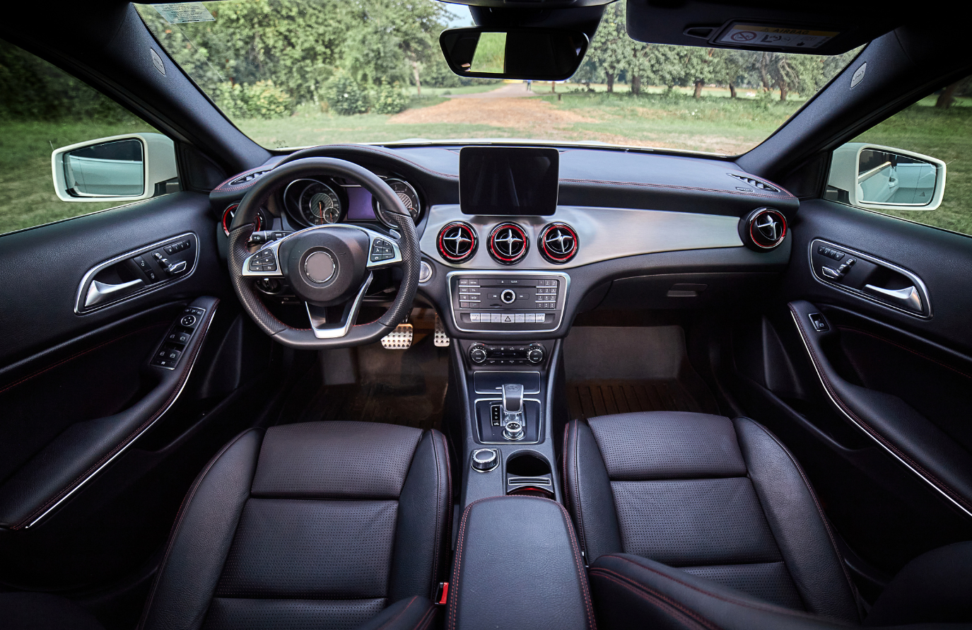 The interior of a car with black leather seats and a steering wheel.