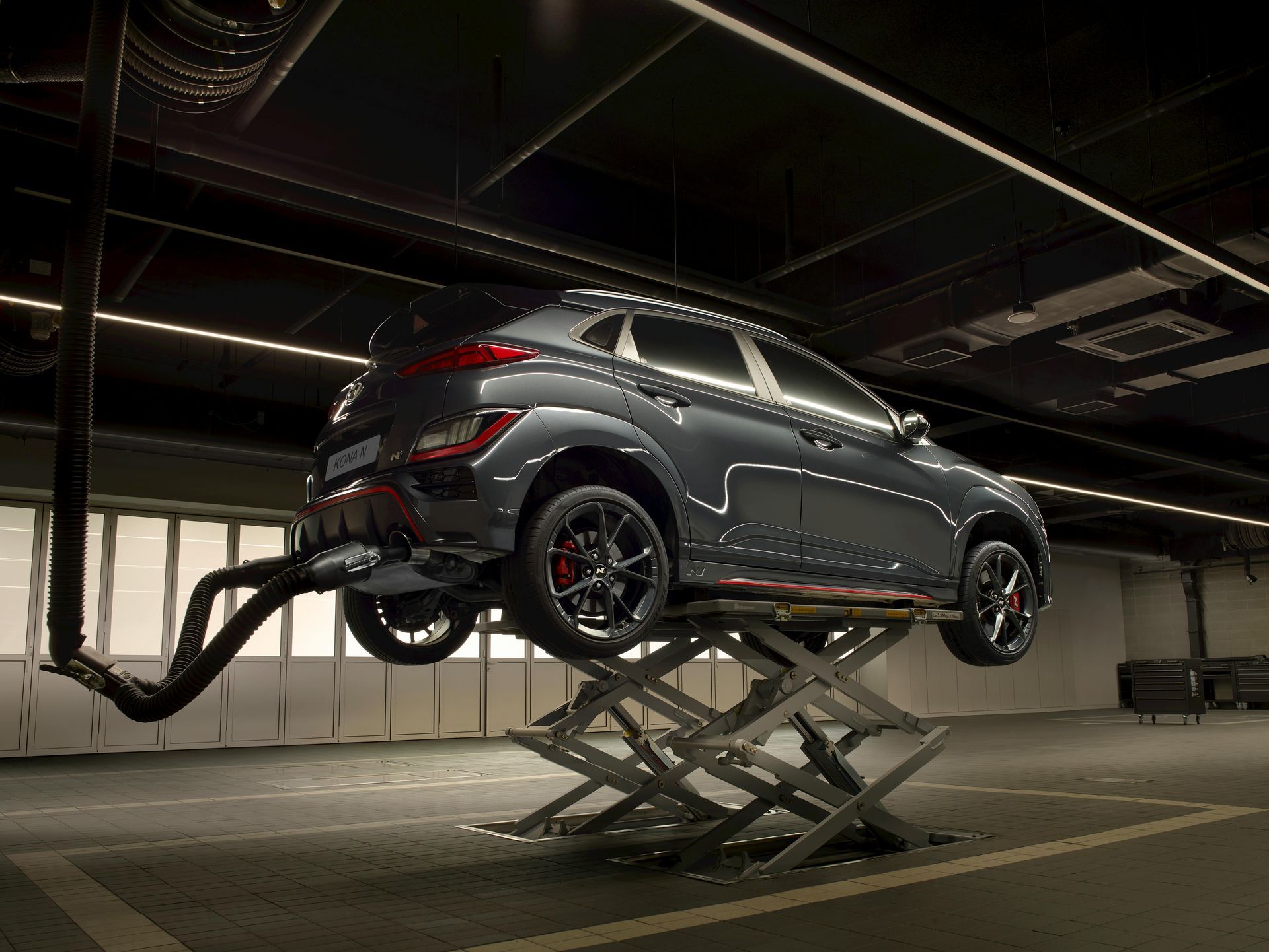 A car is sitting on a lift in a garage.