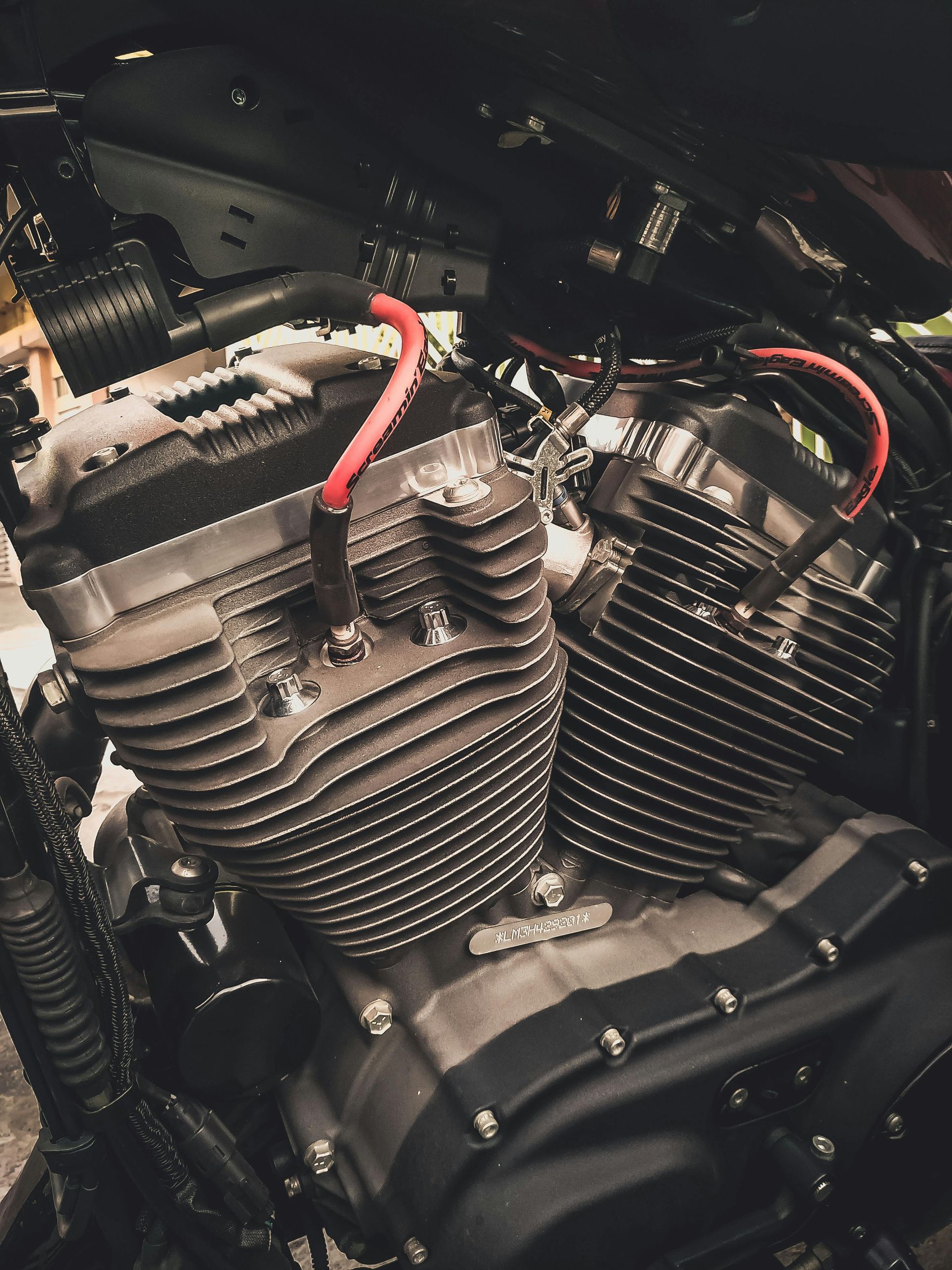 A close up of a motorcycle engine with red wires coming out of it
