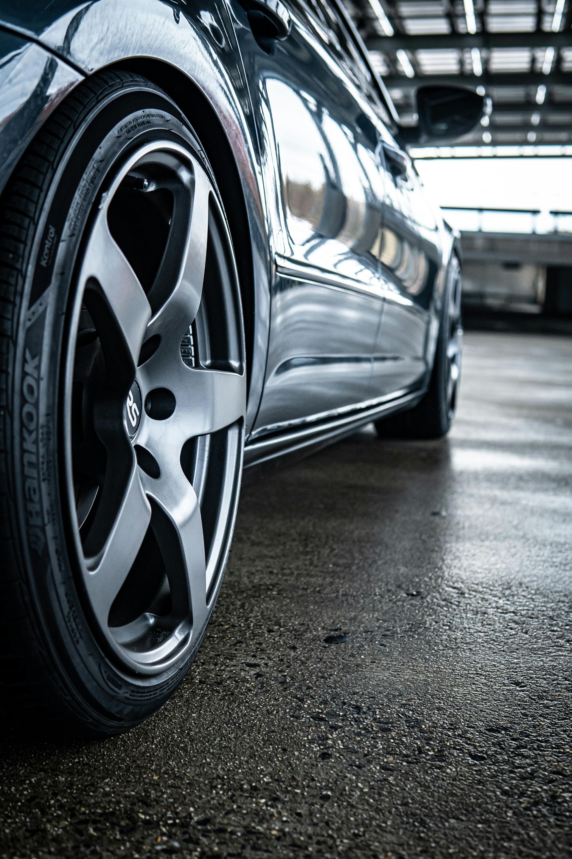 A close up of a car wheel in a parking garage.