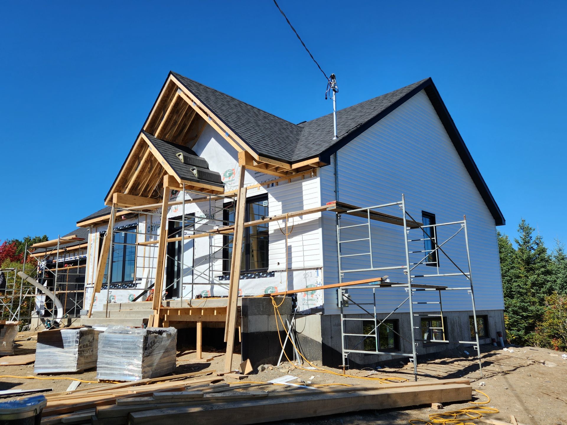 Une maison est en construction avec des échafaudages autour.