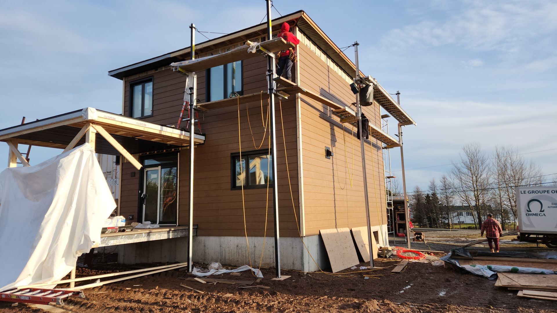 Une maison est en construction avec des échafaudages autour.