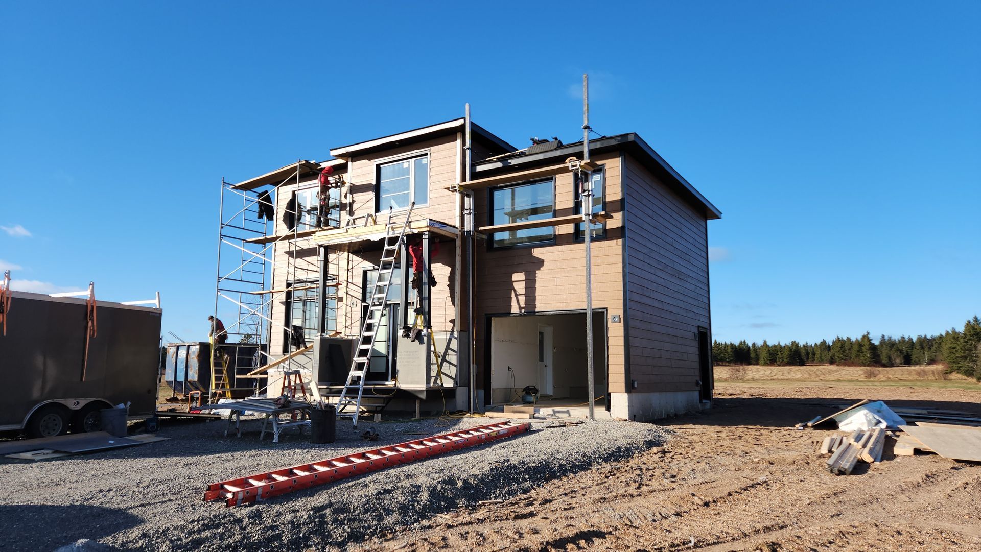 Une maison est en construction au milieu d'un champ de terre.