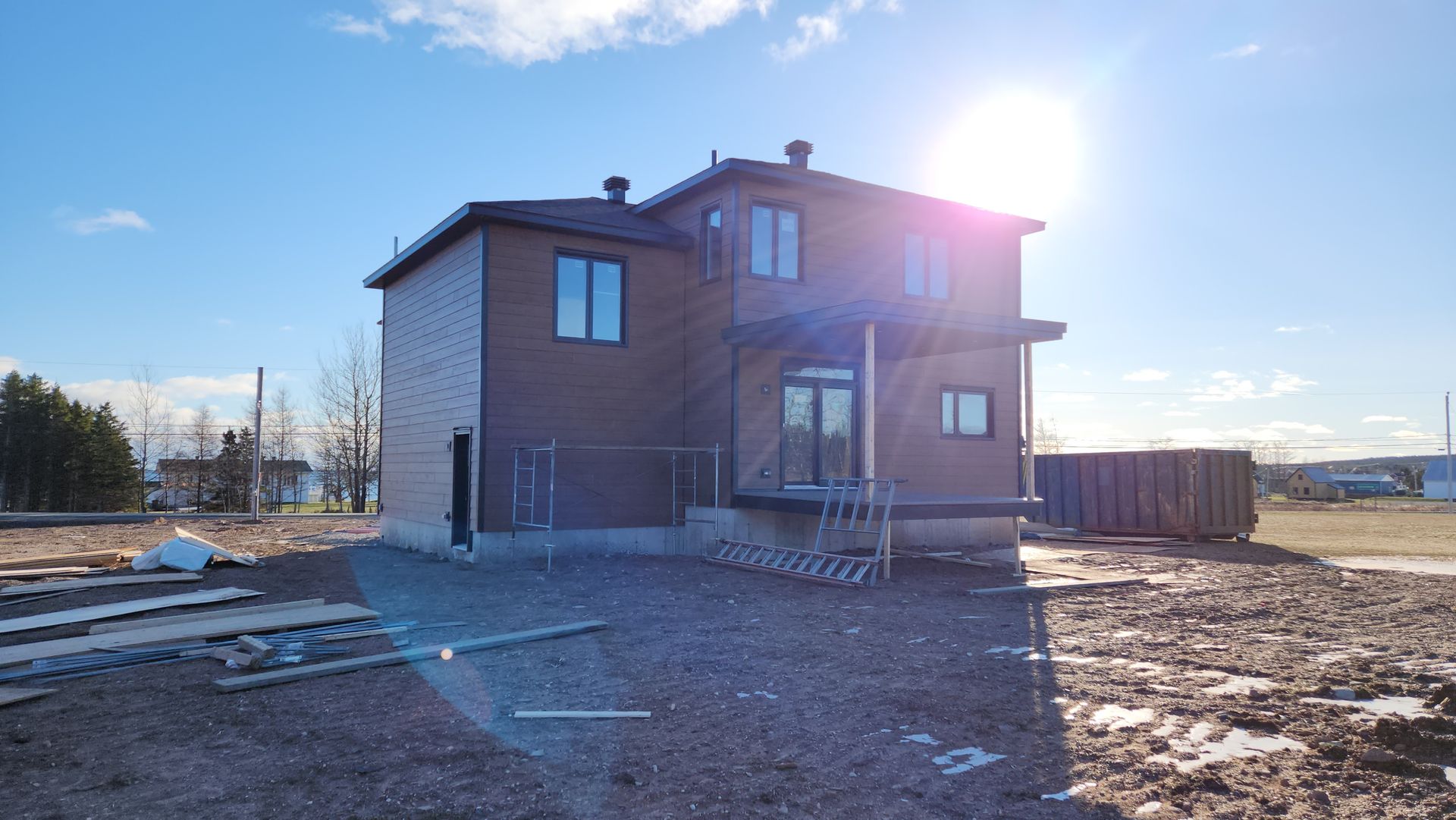 Une maison est en construction au milieu d'un champ de terre.