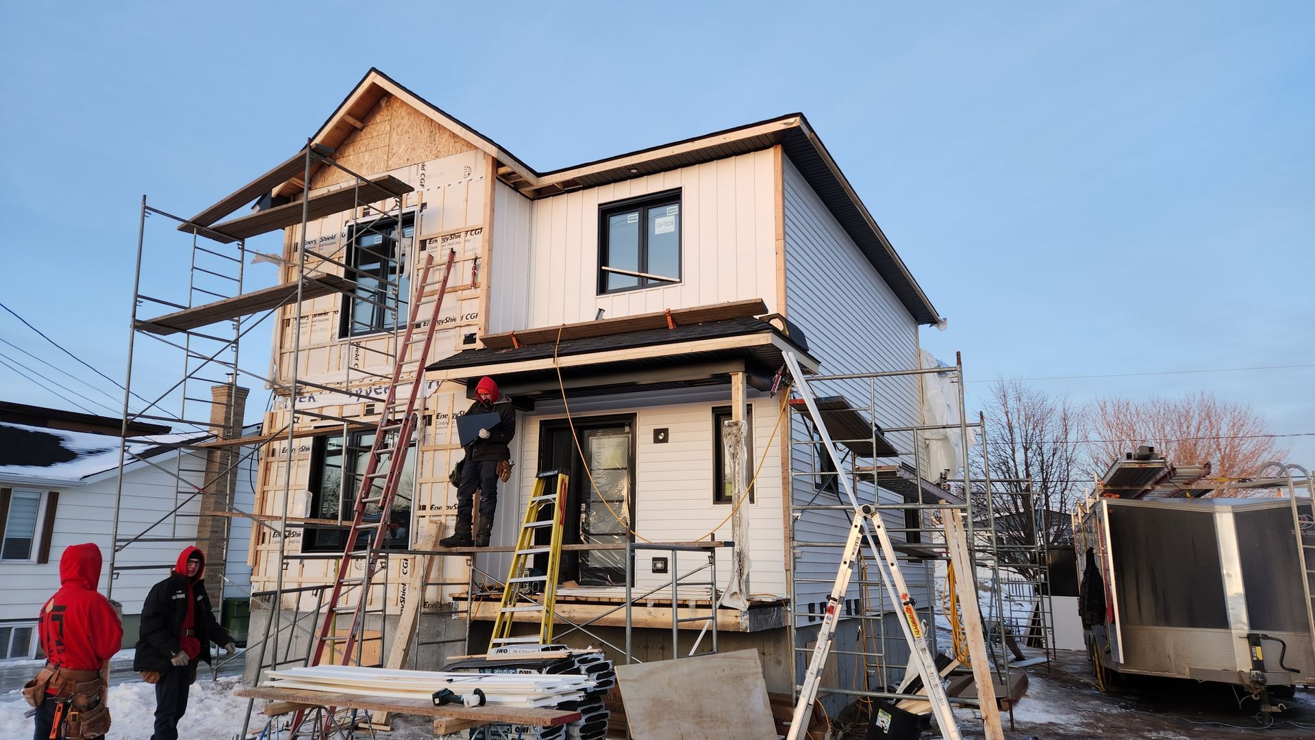 Une maison est en construction avec des échafaudages autour.