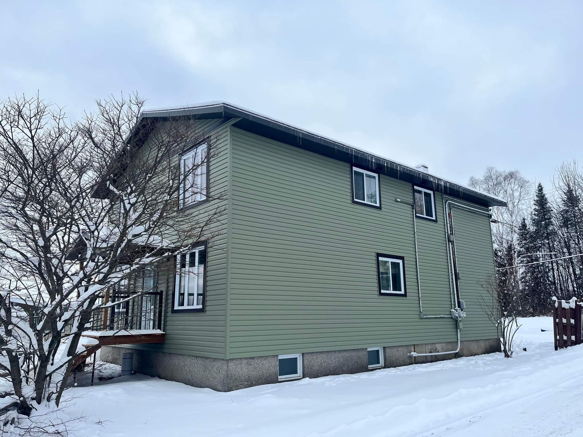 Une serre avec de nombreuses fenêtres est recouverte de neige.