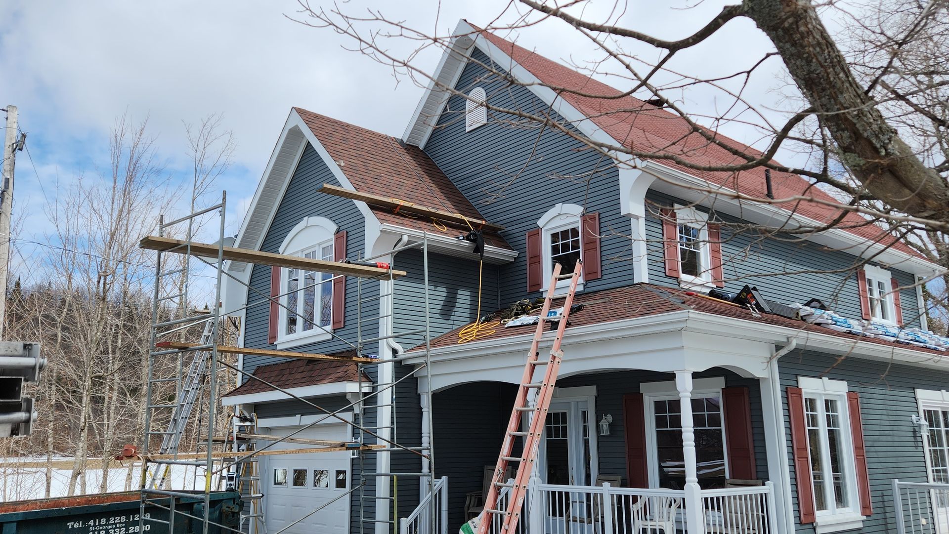Une grande maison au toit rouge est en cours de rénovation.