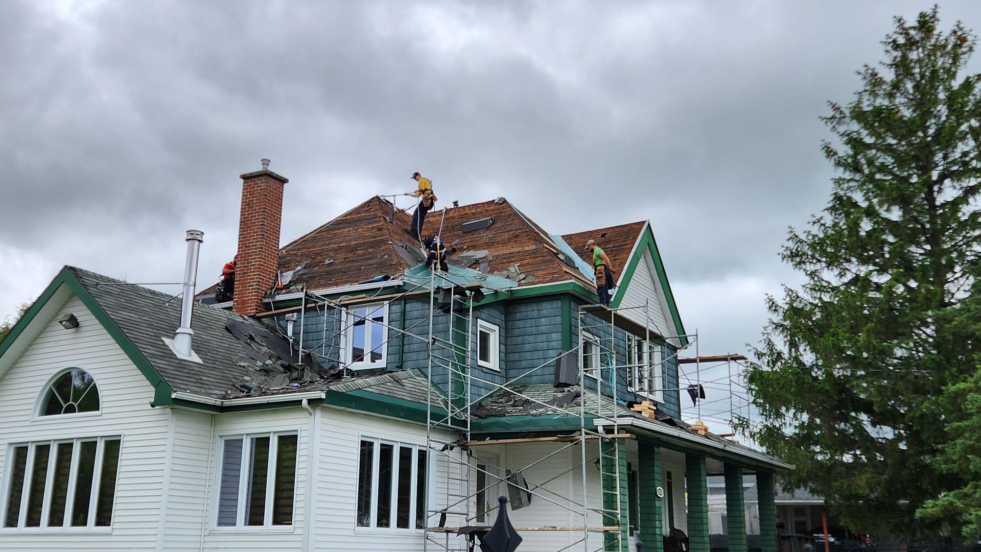 Un homme est debout sur le toit d'une maison.