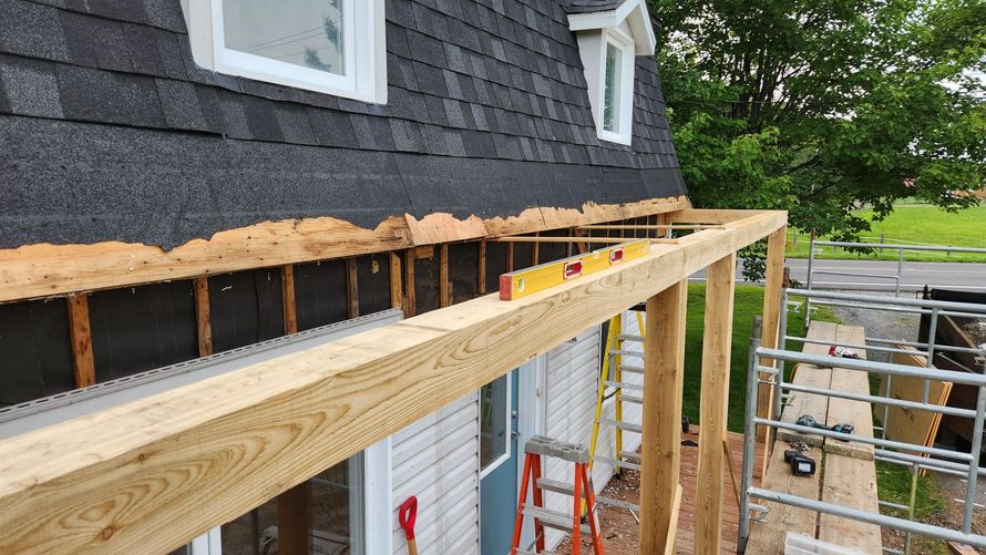 Une terrasse en bois est en cours de construction sur le côté d'une maison.