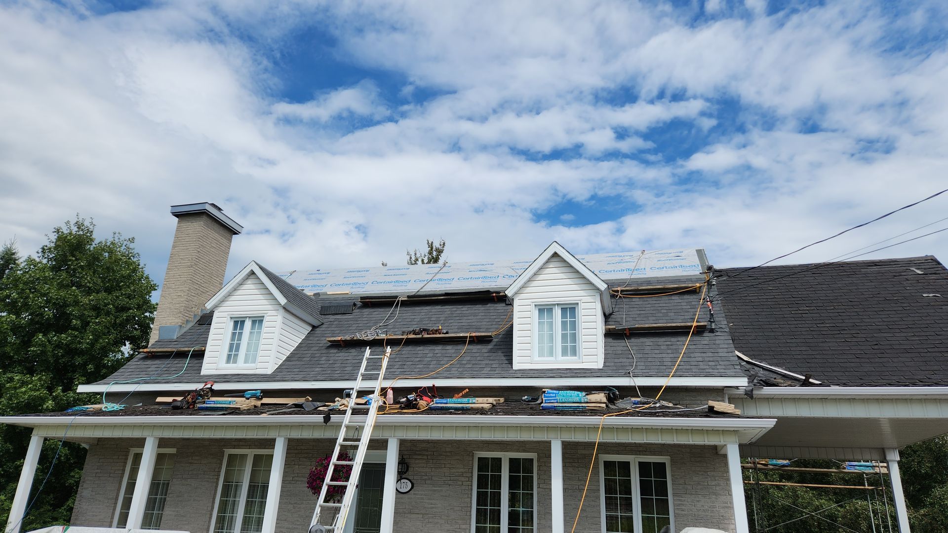 Une maison est en cours de rénovation avec une échelle sur le toit.