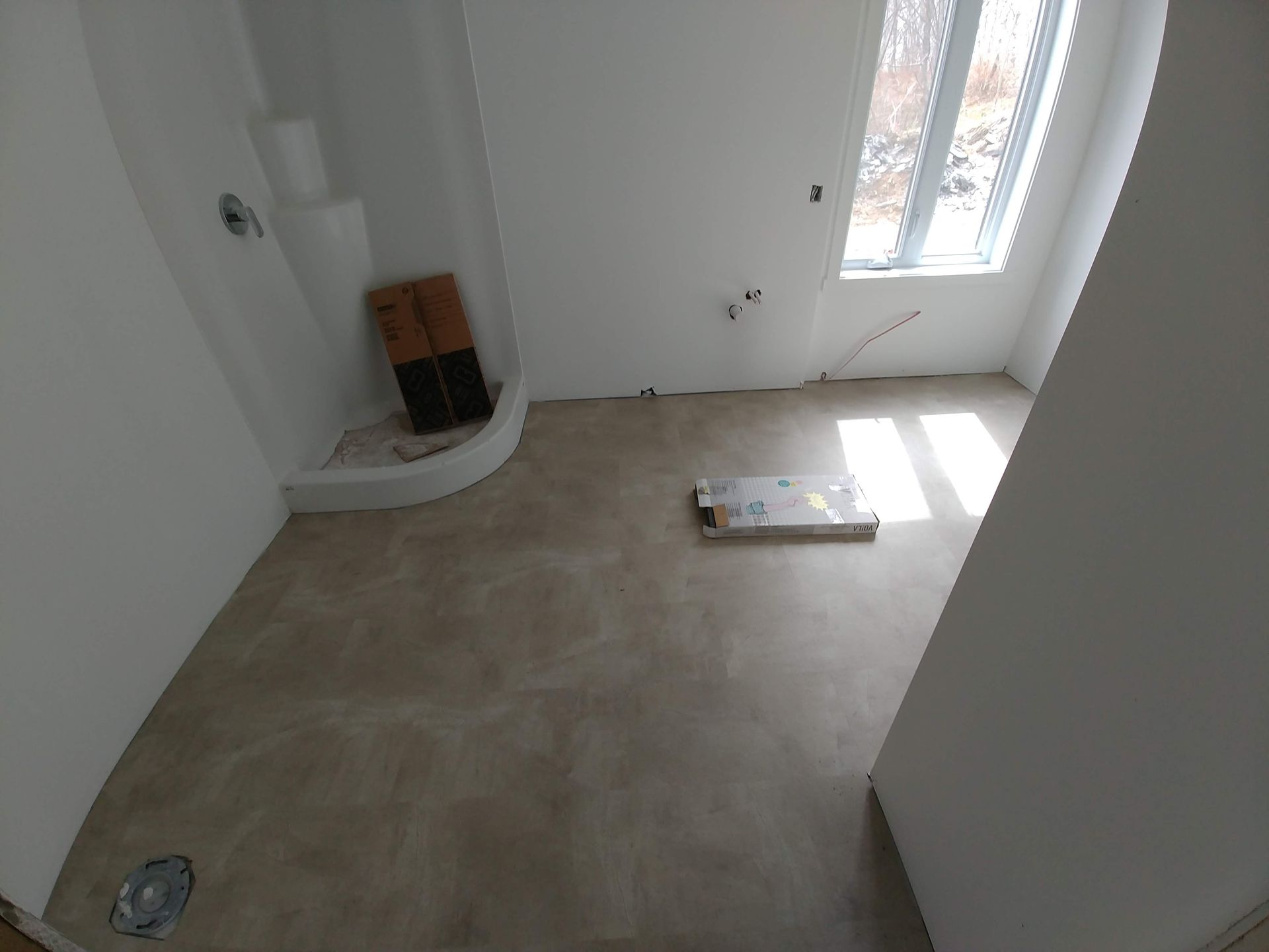 Une salle de bain avec douche et box au sol.