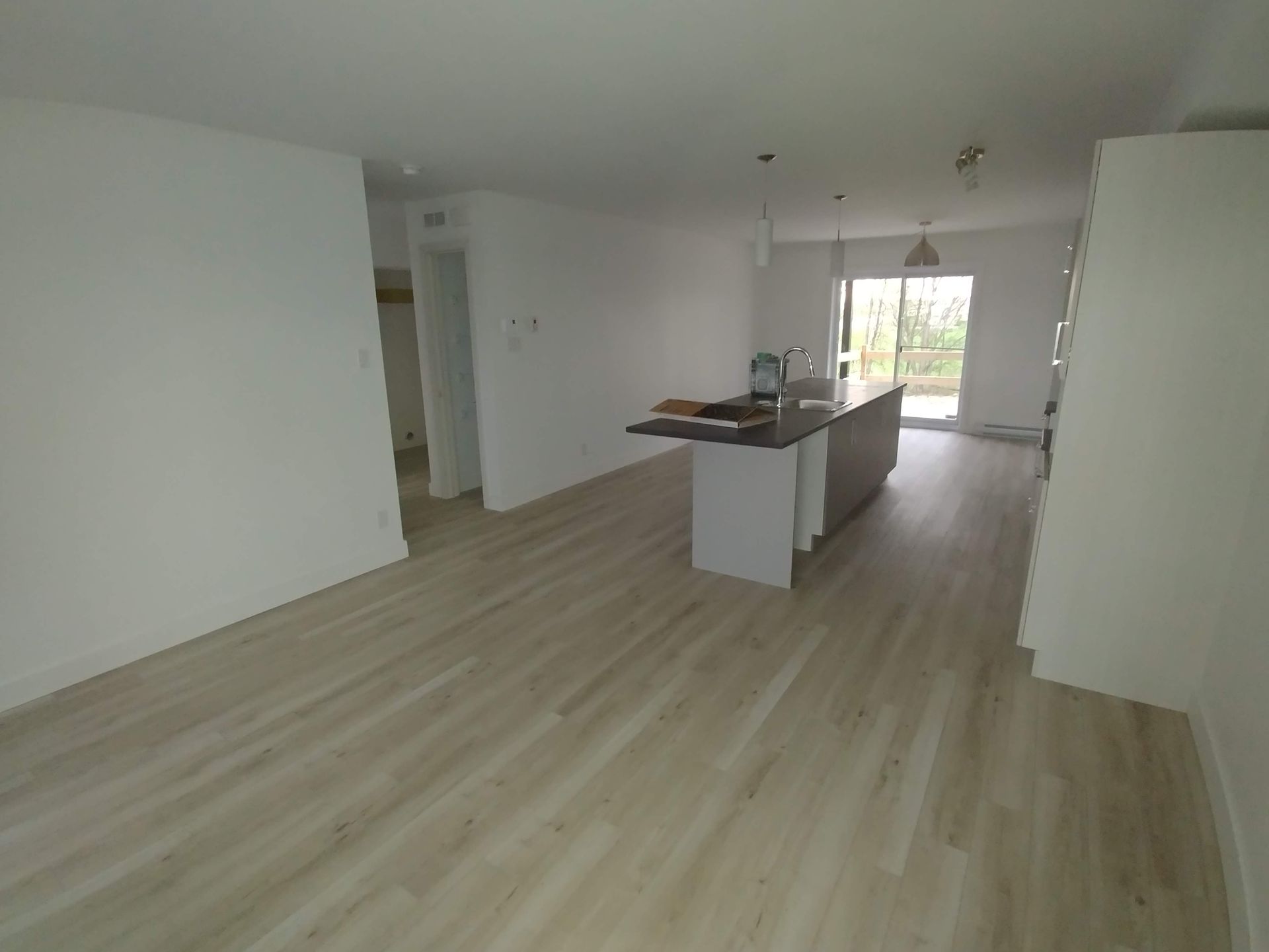 Une pièce vide avec un parquet et des murs blancs