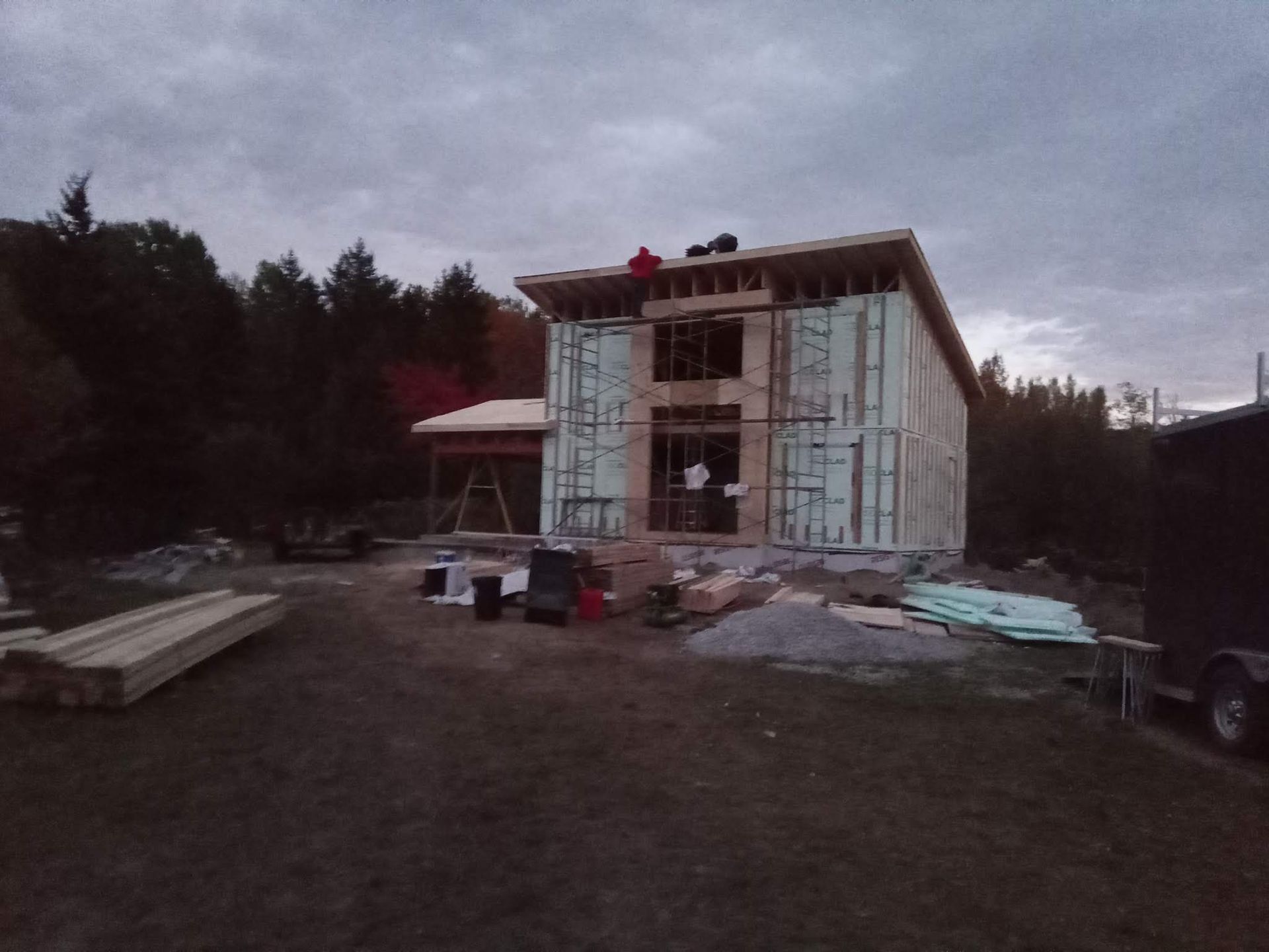 Une grande maison est en construction au milieu d'un champ.