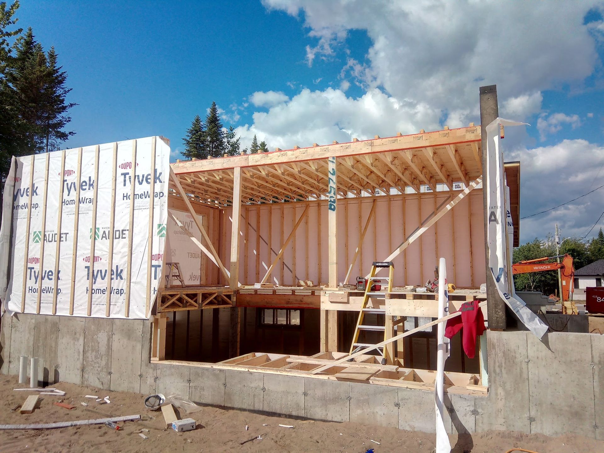 Une maison en construction avec une échelle devant elle