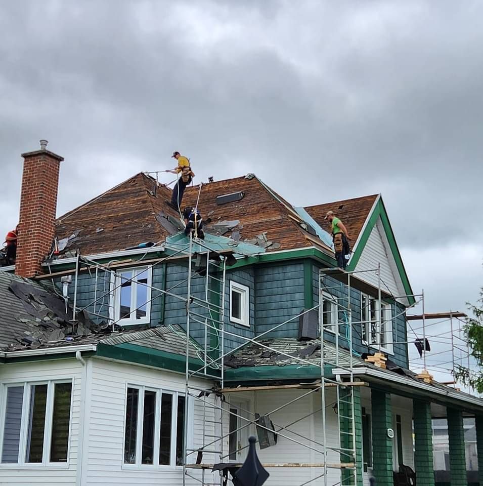 Un groupe d'hommes travaille sur le toit d'une maison.