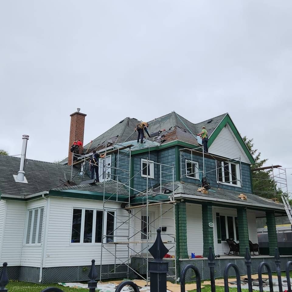 Un groupe de personnes travaille sur le toit d'une maison.