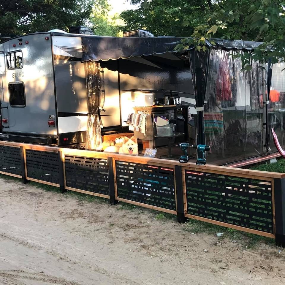 Un camping-car est garé derrière une clôture en bois