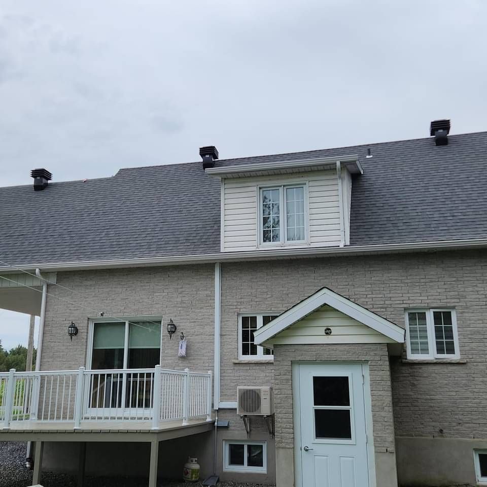 Une maison avec un toit gris et une porte blanche