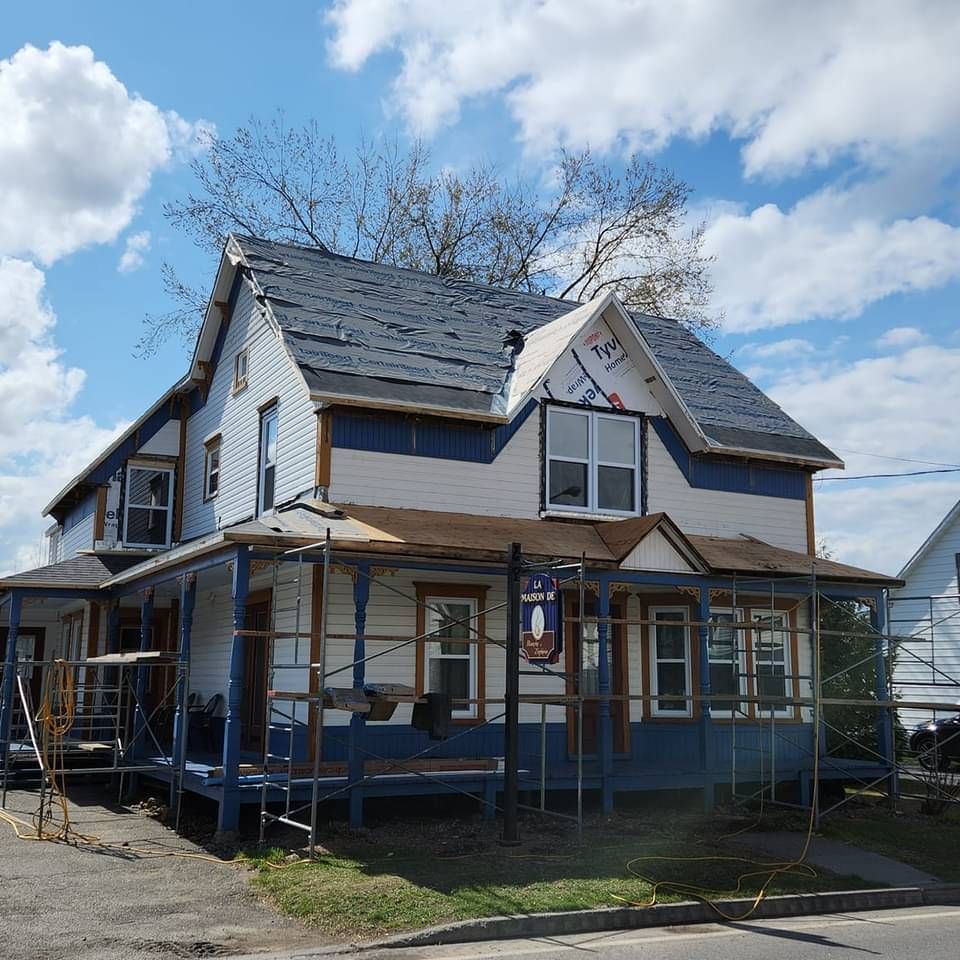 Une maison blanche avec un porche bleu et un panneau indiquant « a » dessus